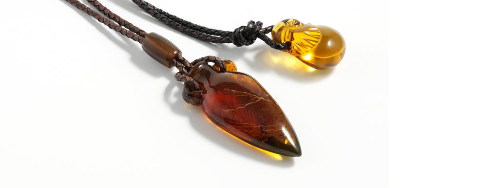 Dominican amber Amphora pendant, braided leather cord. Carved snale pendant, braided leather cord.
